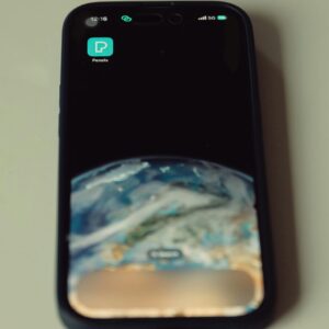 Close-up of smartphone showing Earth wallpaper and Pexels app icon on screen.
